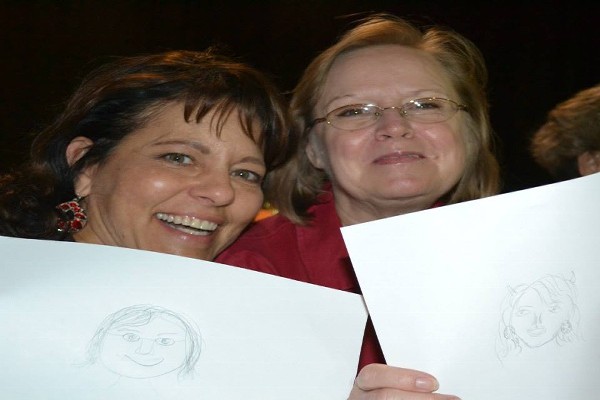 Two Women Holding Drawings